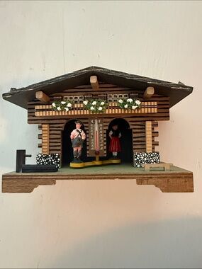 German Toggili weather station with decorative home piece and figurines.